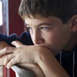 Child looking through window